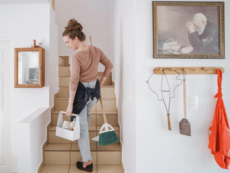 A cleaner carrying supplies up the stairs of a home
